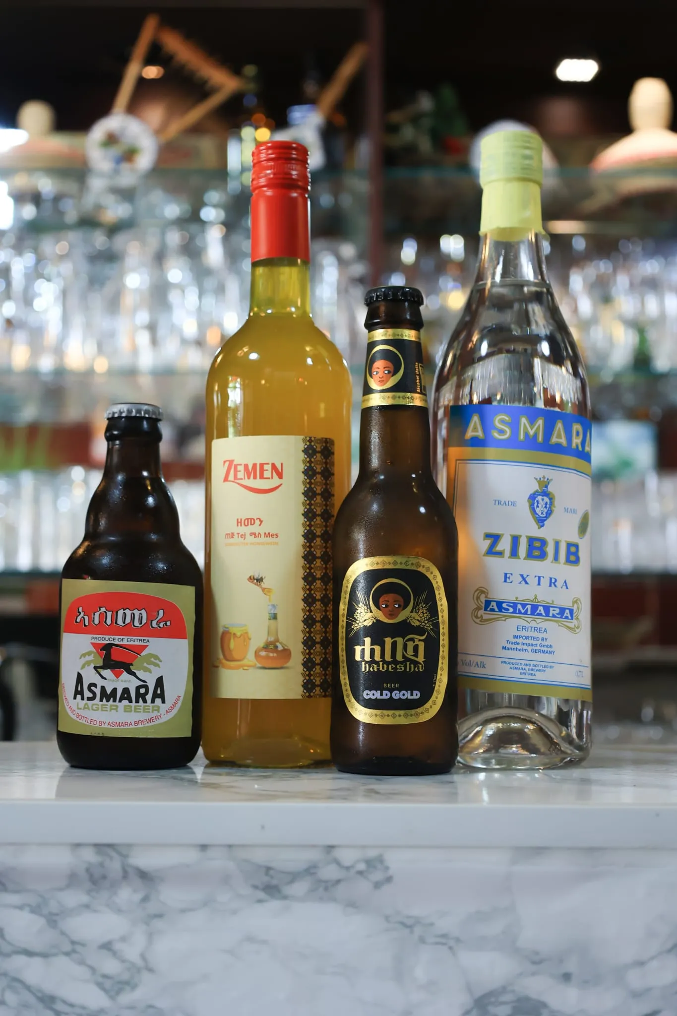 Vier eritreische Getränke auf der Bar: Asmara Lager Beer, Zemen Honigwein, Habesha Cold Gold und Asmara Zibib